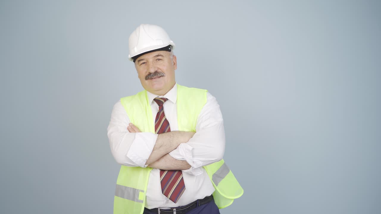 el ingeniero cruza los brazos y se ríe de la cámara.