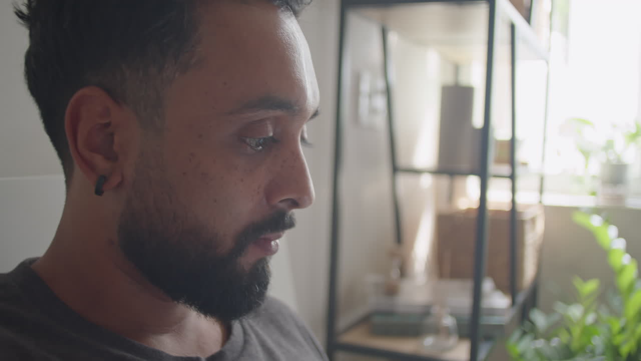 Uomo che usa il telefono mentre fa colazione a letto