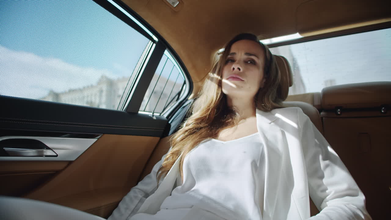 지친 사업가 여성이 차에서 진정하고 있습니다.