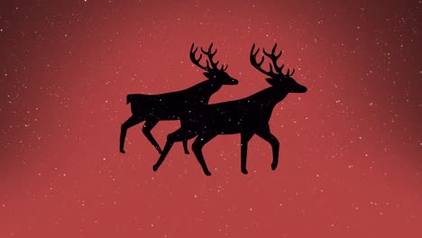 snow falling over silhouette of two reindeers walking against orange background