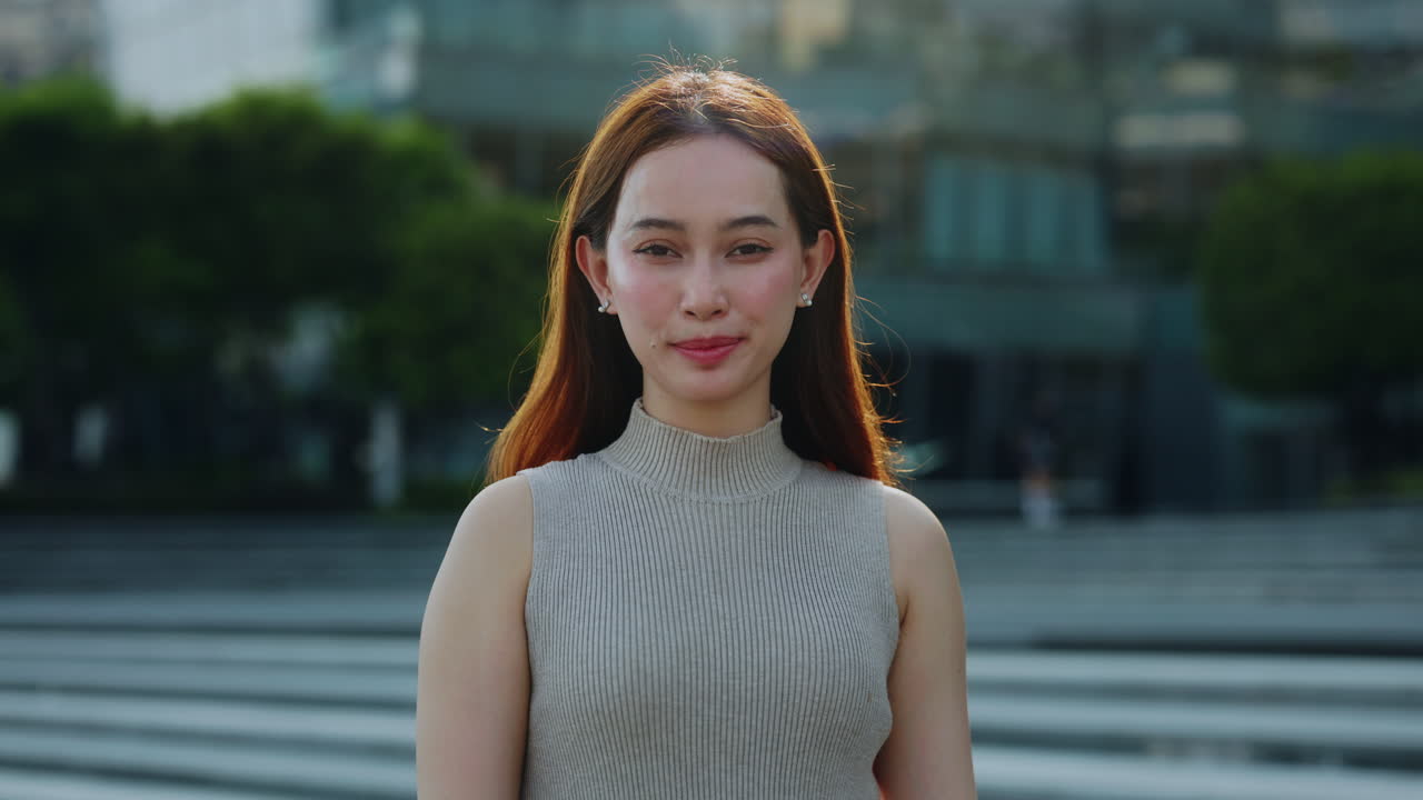 都市の屋外で幸せそうに微笑む若いアジア人女性