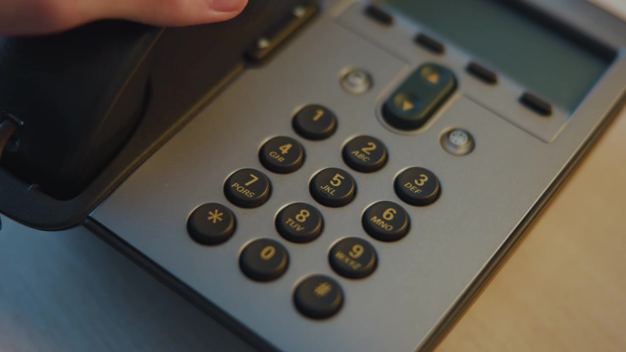 Closeup Office Phone Keypad On Desk, Sleek Silver Handset Shadowed By Warm Lamp, Black Tactile Buttons