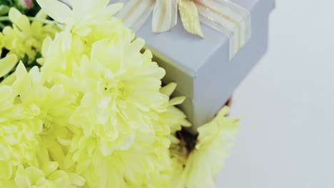 Gift-box-and-bunch-of-yellow-flowers-in-wicker-basket-with-happy-mothers-day-tag