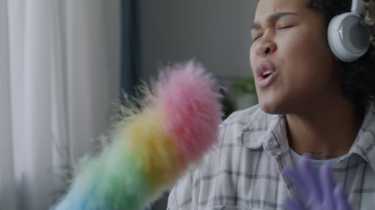 Happy Woman Singing with Dusting Brush as Microphone