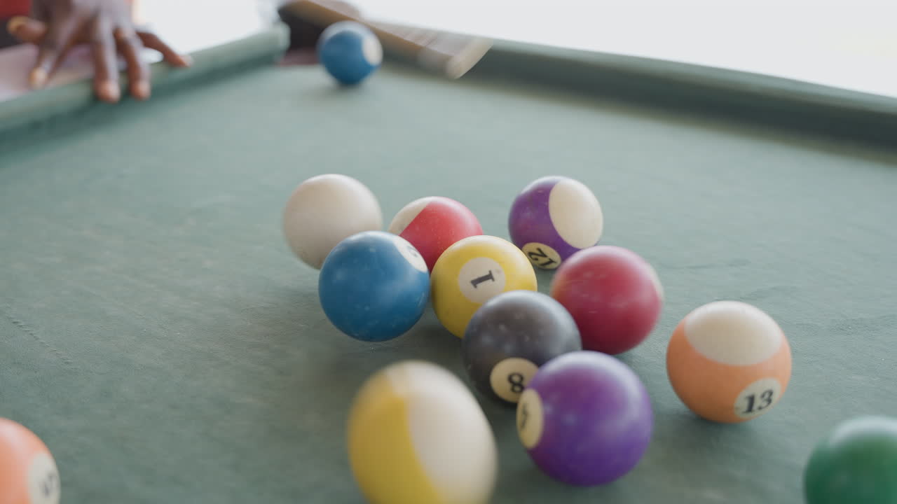 Racked pool balls on green felt, closeup of player lining up break with cue and white ball, hands steady on table edge, soft natural light, casual indoor club atmosphere, tense focus before shot