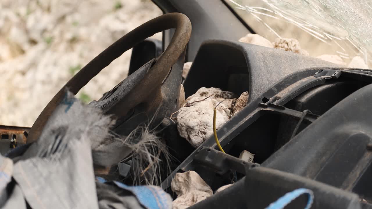 dentro de la cabina de una vieja furgoneta abandonada, llena de rocas y basura