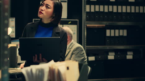 un investigador privado buscando viejas carpetas en el archivo.