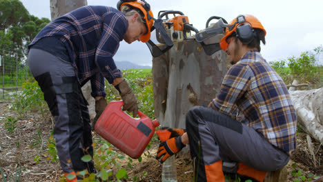 two lumberjacks pouring oil on bottle 4k