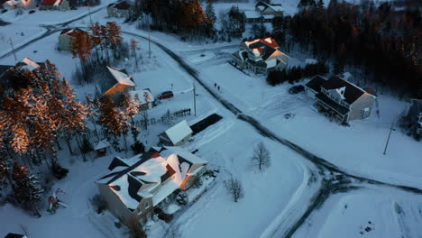 winter aerial view looking down on snow covered homes in a suburban subdivision