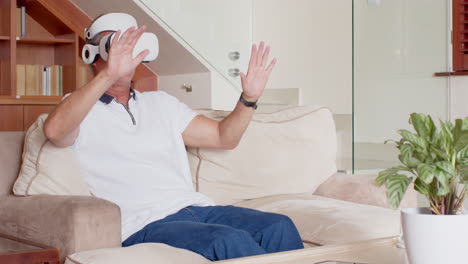 senior man using virtual reality headset, sitting on sofa, exploring technology, copy space