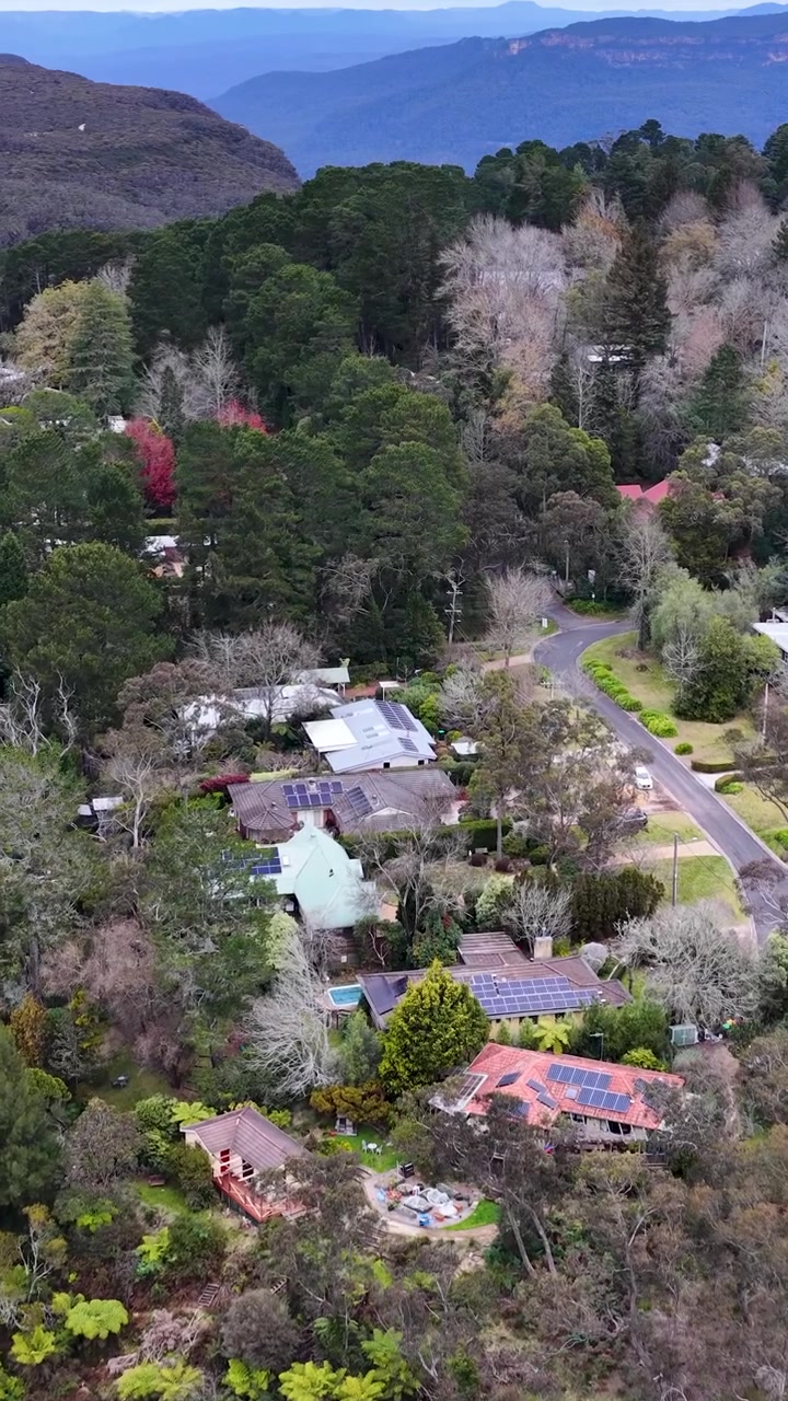 Toma aérea con dron de casas entre árboles de eucalipto en Wentworth Falls, Australia