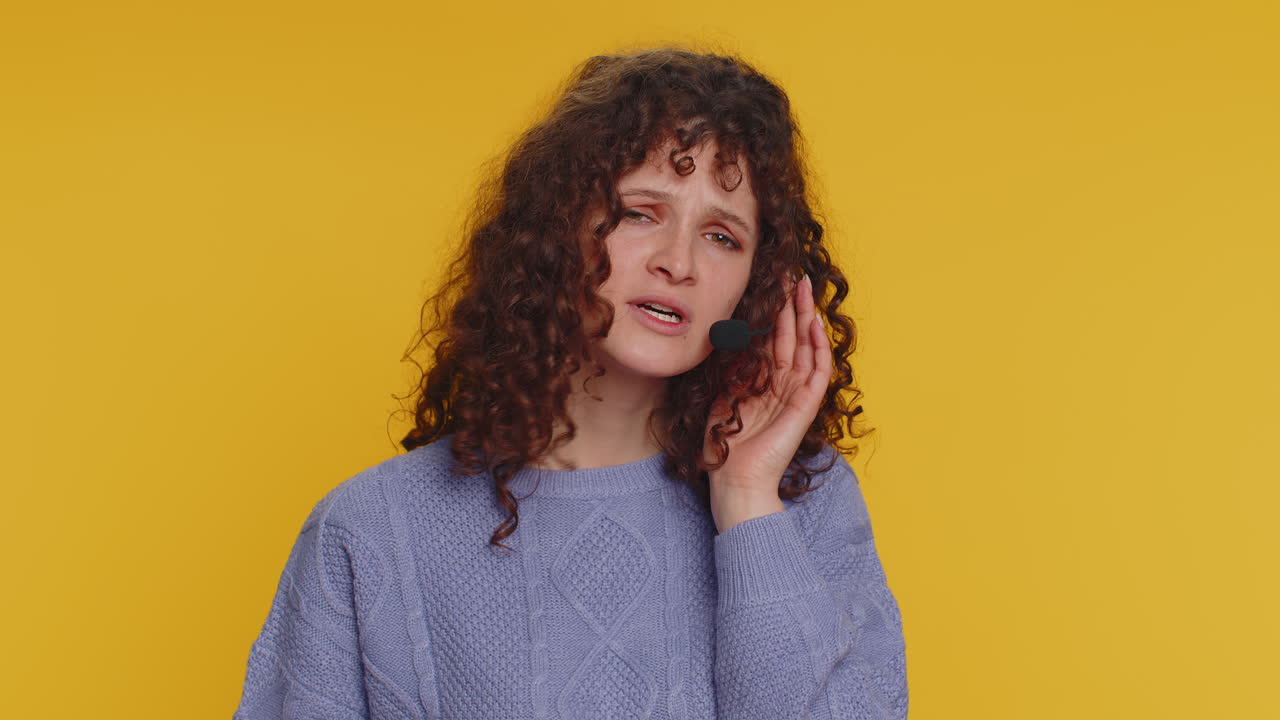 mujer con auriculares con micrófono, mirando hacia abajo, expresión seria