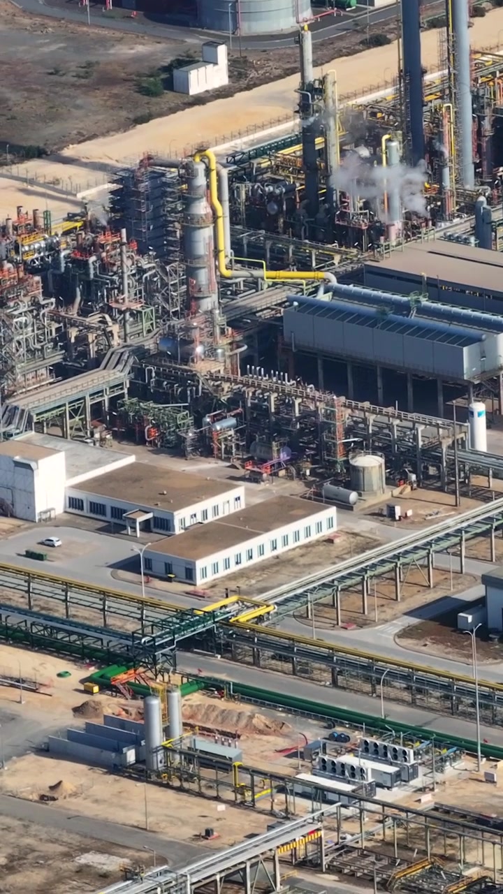 An oil refinery complex engaged in various petrochemical industry processes. The energy infrastructure is prominently displayed, emphasizing its operational scale.