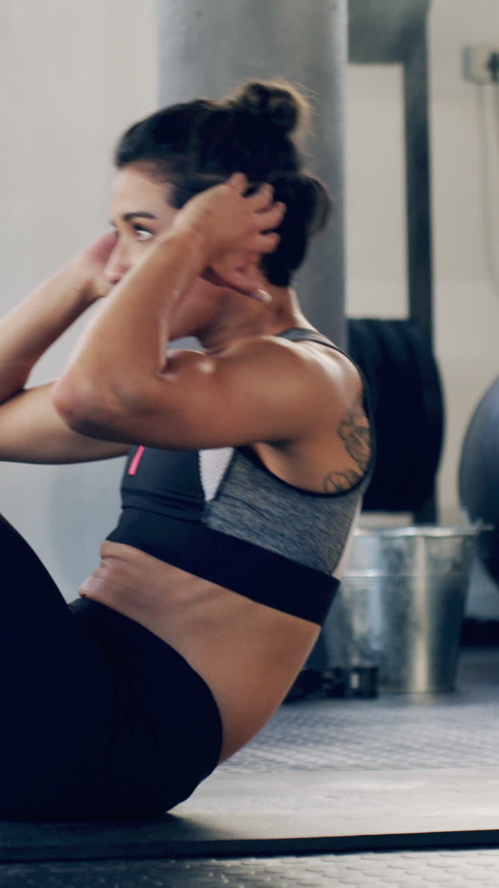 Donna che fa addominali su un tappetino per esercizi in palestra