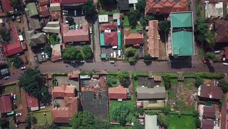 drone mira hacia abajo a una calle, carretera y zona de viviendas en la ciudad de kampala, uganda