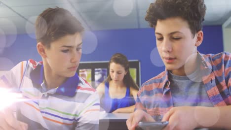 Bokeh-Animation-über-Zwei-Männliche-Schüler,-Die-In-Der-Schule-Ihr-Smartphone-Benutzen