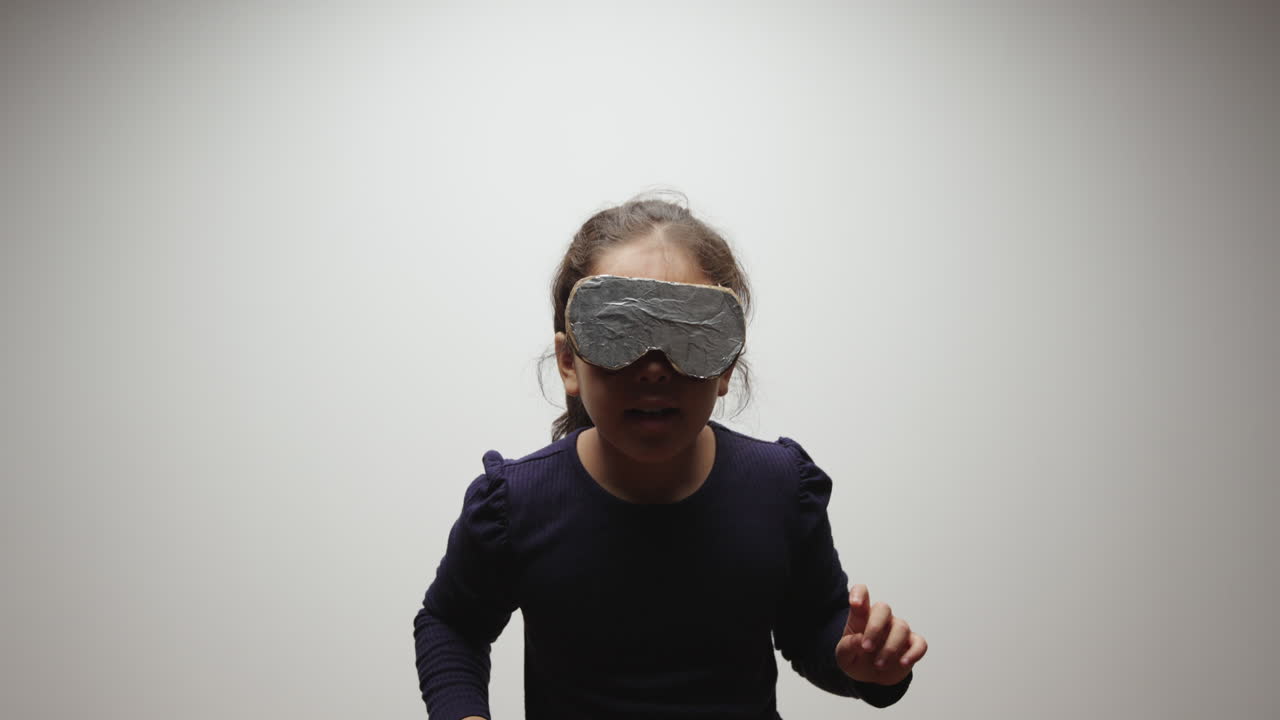 Young Girl Wears Cardboard and Aluminum Foil VR Headset and Imagines Virtual World