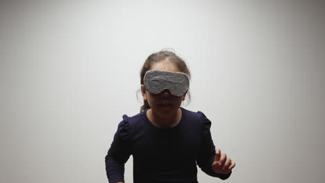 young girl wears cardboard and aluminum foil vr headset and imagines virtual world