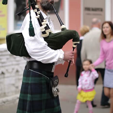 bagpiper in traditional scottish clothes