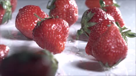 strawberries rolling down on white background. slow motion