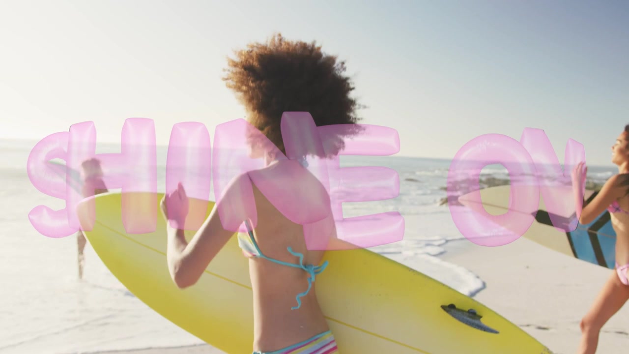 Mujer líder sosteniendo una tabla amarilla dirigiéndose a surfear, cámara siguiendo desde atrás, con superposición rosa de 'SHINE ON'.