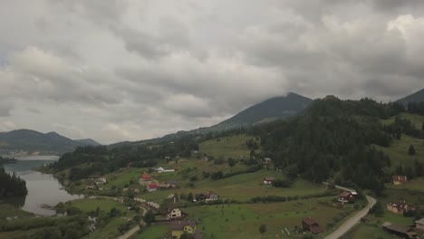 Luftpanoramablick-Auf-Das-Tal-Um-Den-Colibita-See-In-Rumänien-Mit-Blick-Auf-Die-Häuser-Und-Den-See