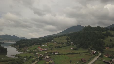 Vista-Panorámica-Aérea-Del-Valle-Alrededor-Del-Lago-Colibita-En-Rumania-Con-Vistas-A-Las-Casas-Y-Al-Lago