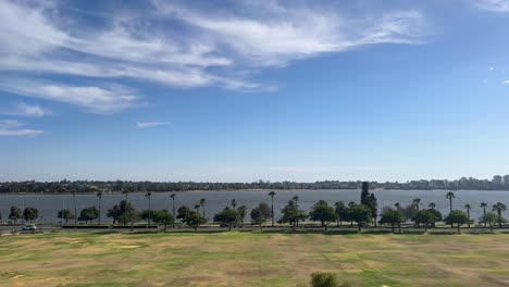 riverside drive in perth, western australia with palm trees along the swan river with wispy clouds above on a blue sky day