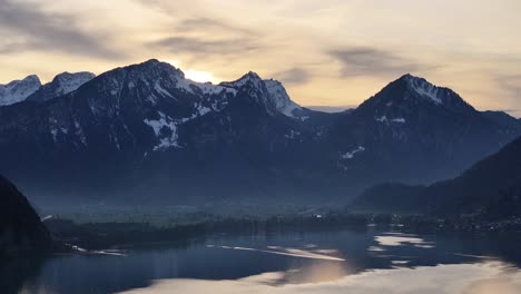calm lake surface at sunset behind the mountains