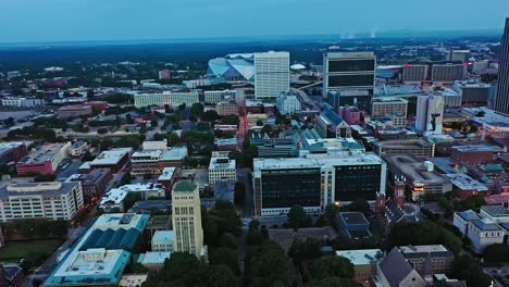 aerial birds eye of city downtown in atlanta at dawn. golden cupola of georgia state capital and mercedes benz stadium in background. wide shot.