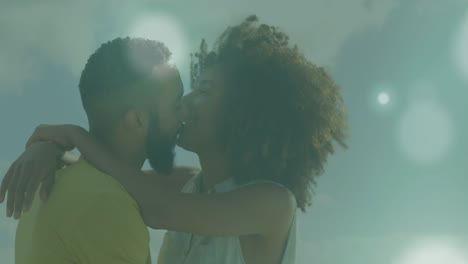 Animation-of-spots-of-light-against-african-american-couple-embracing-each-other