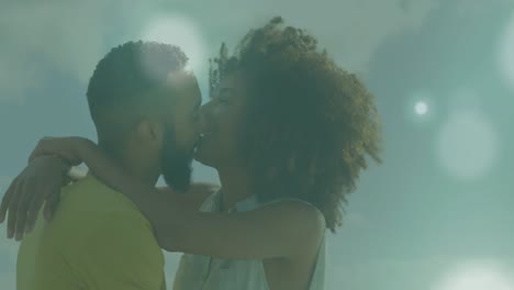 animación de puntos de luz contra una pareja afroamericana abrazándose entre sí