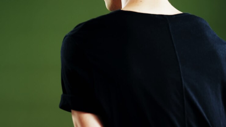 Androgynous man posing against green background