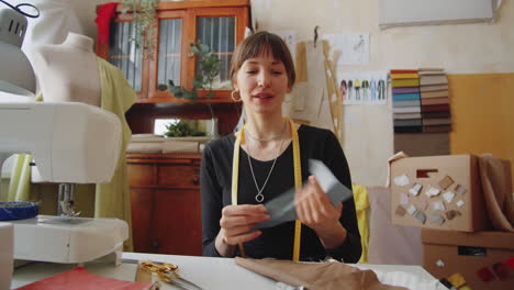 female dressmaker telling about fabric at camera