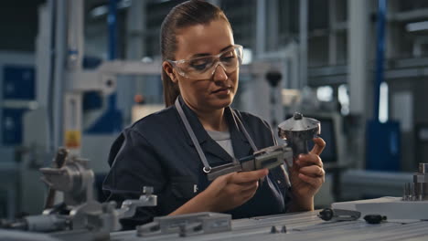 female engineer inspecting metal part in a factory