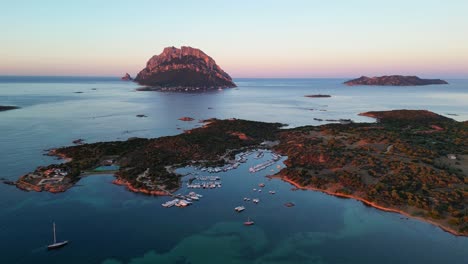 Tavolara-Island-and-Porto-San-Paolo-during-sunset-in-Sardinia,-Italy---Aerial-4k