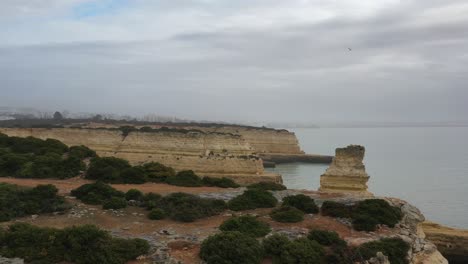 fontainhas beach in south portugal with eroded rock formations over the atlantic ocean, aerial flyover