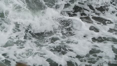 cámara lenta de espuma con olas rompiendo en ella