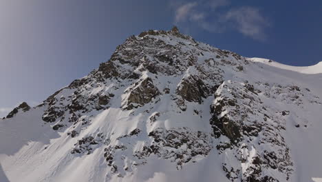 aerial footage of the iconic freeride paradise of verbier on a stunning bluebird day. snow-covered peaks, wide open faces, and legendary off-piste terrain under clear alpine skies