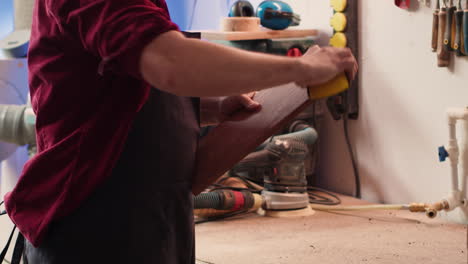 artisan with safety glasses next to apprentice using sanding block