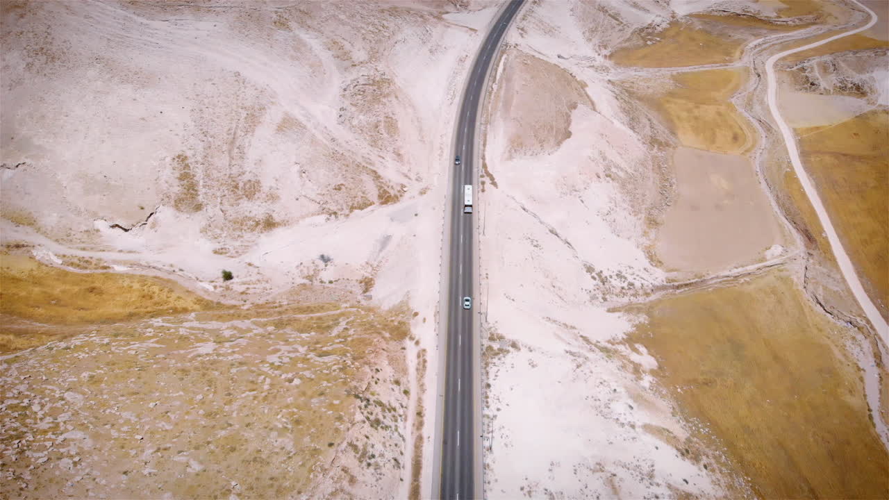 Bus driving on Straight line Highway in the desert aerial view
