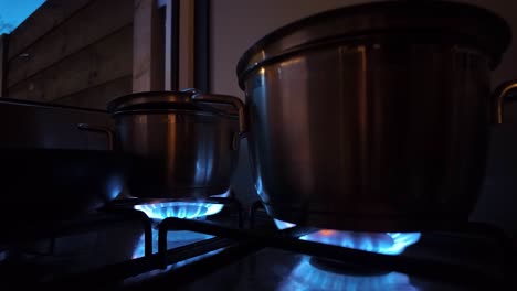 stainless steel pots over fire on cooking stove in the kitchen