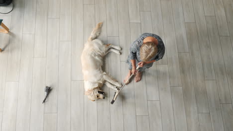 woman cleaning floor with dog