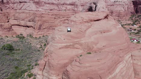 off-road jeep vehicle on southwest desert cliff near moab, utah - aerial