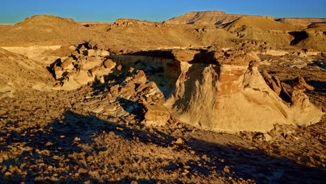 a slow-moving drone captures the surreal landscape of multi-toned hills and rock spires near the utah-arizona border.