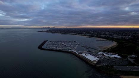 Aerial-toward-Sandringham-Yacht-Club-moody-sunrise,-Melbourne