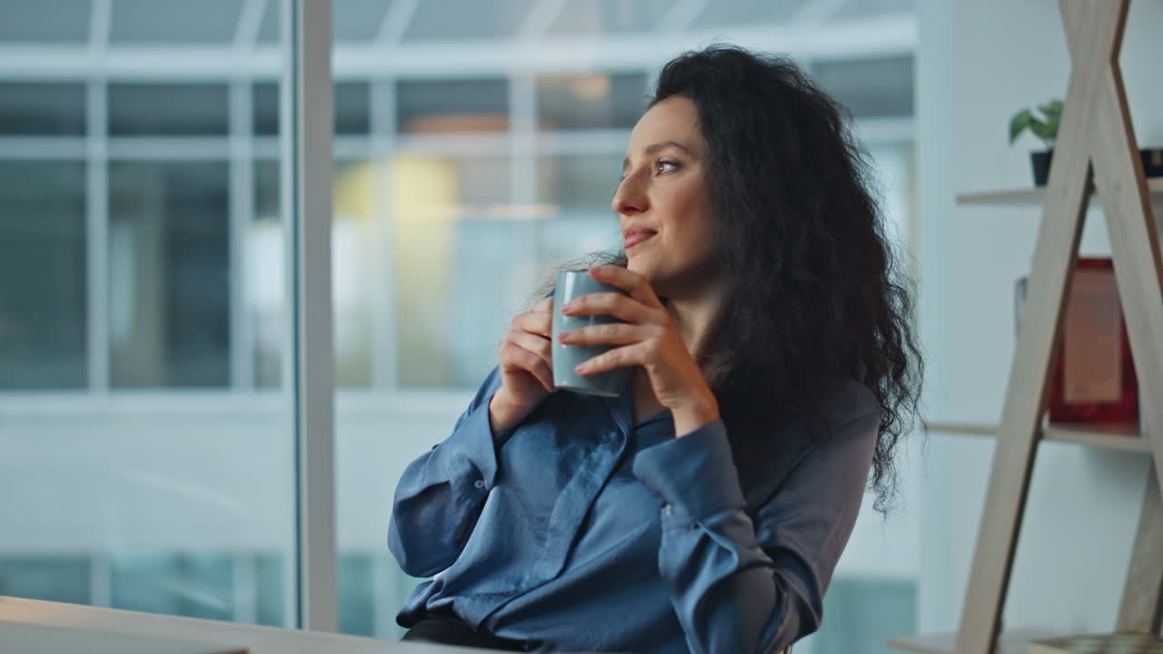 Smilende forretningskvinde drikker kaffe i en stol. Nærbillede af afslappet leder, der hviler sig.