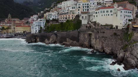 seafront hotels on coastal cliff with waves crashing