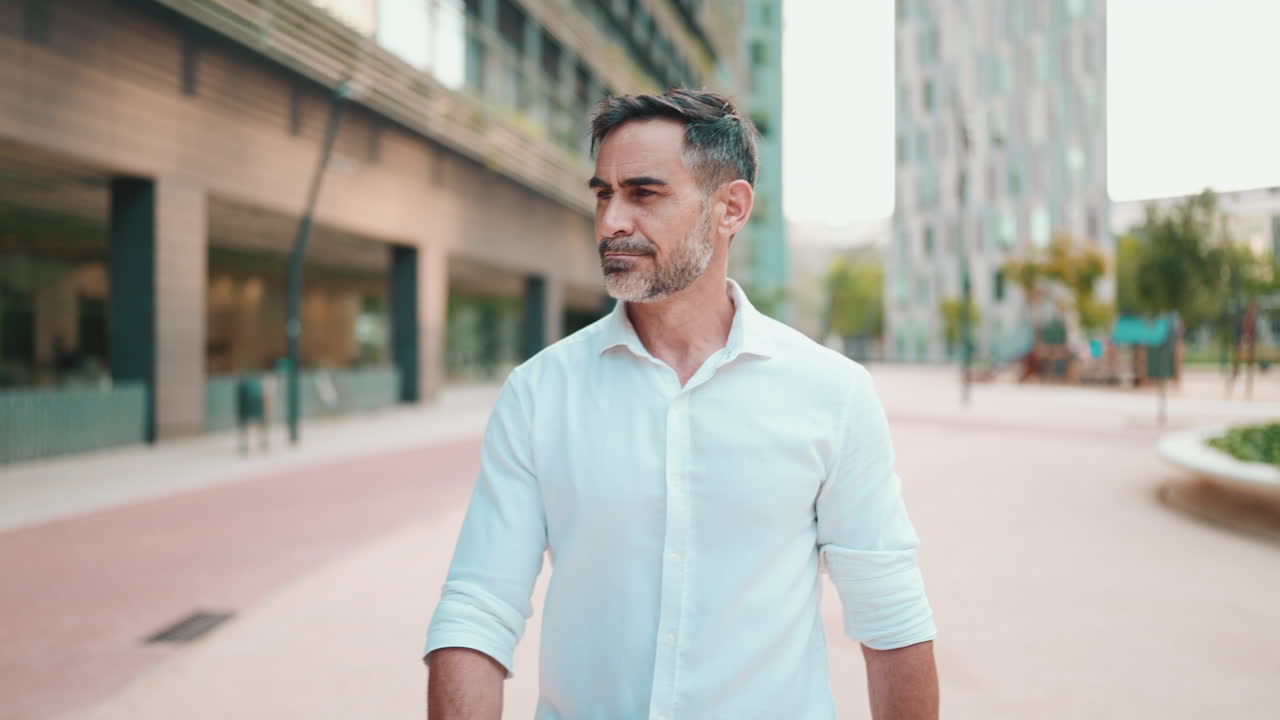 Uomo con una camicia bianca che cammina in città