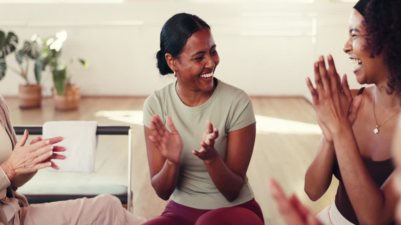 Group of women laughing and bonding in a yoga studio
